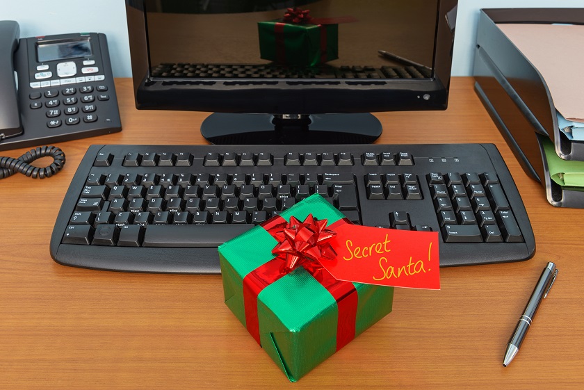 Office Christmas secret Santa gift wrapped present and tag on a desk
